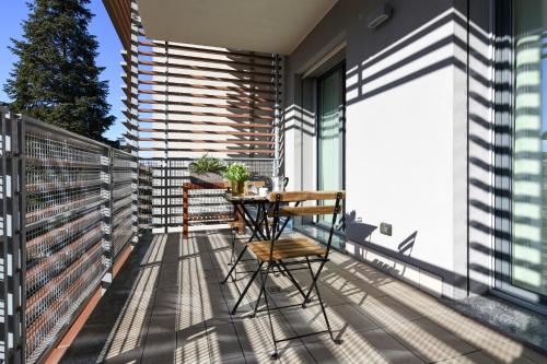 a balcony with a wooden table and chairs at CaseOspitali - Casa Marina grande bilocale con terrazzo perfetto x2 in Cernusco sul Naviglio