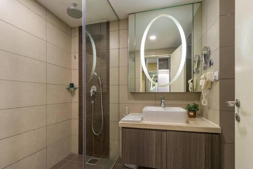 a bathroom with a sink and a shower with a mirror at Koyama Zen Studio at Ion Delemen in Genting Highlands