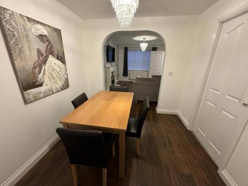 a dining room with a wooden table and chairs at Modern 3 Bedroom House Close to Liverpool Centre in West Derby