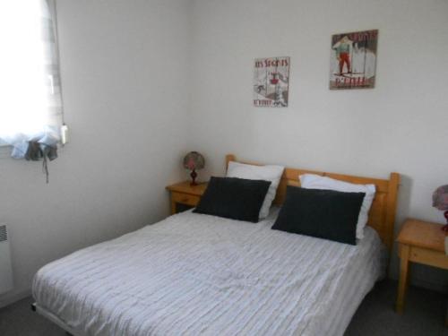 une chambre avec un lit et deux tableaux au mur dans l'établissement Résidence Aspin I - Appartement 6 personnes au centre du village MAE-6184, à Saint-Lary-Soulan