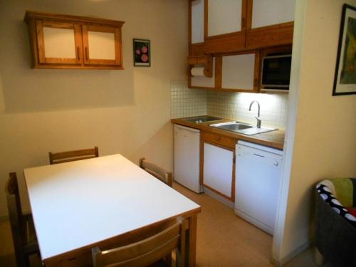 une petite cuisine avec une table blanche et un évier dans l'établissement Résidence Le Parc - Appartement 6 personnes proche du télécabine et des thermes MAE-6194, à Saint-Lary-Soulan