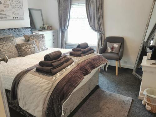 een slaapkamer met een bed met bruine handdoeken erop bij Stunning 2-Bed House in Macclesfield Cheshire in Macclesfield