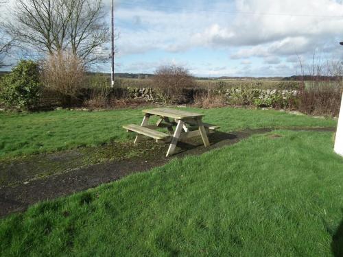 a wooden picnic table in a field of grass at Borrowmoss Bothy, Charming & Characterful property, Wigtown in Wigtown