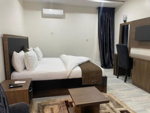 Habitación de hotel con cama y TV en Elimus Apartments & Suites, 