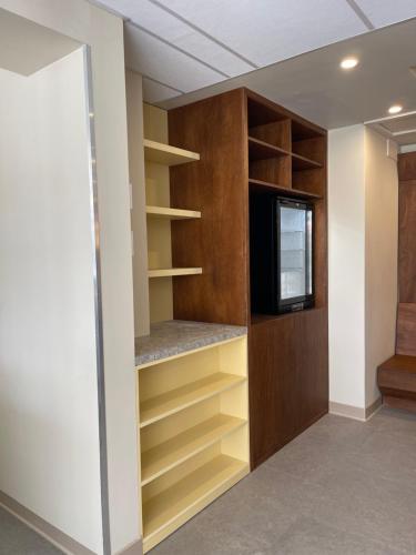 a walk in closet with a tv and shelves at Hotel des Victoires in Cannes