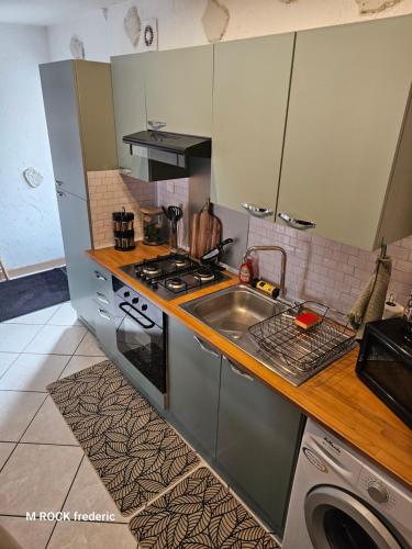a kitchen with a sink and a stove at maison de ville avec jardin privatif in Nevers