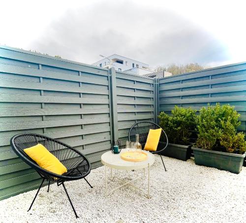 a patio with two chairs and a table with yellow pillows at Apartment M4 in Salzburg