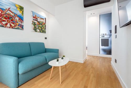 a living room with a blue couch and a table at Hibrido Boutique Hotel & Spa in Sciacca