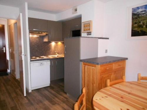 Il comprend une petite cuisine avec une table en bois et du parquet. dans l'établissement Résidence Pre St Jacques - Appartement 6/8 personnes au village de VIGNEC MAE-6264, à Vignec