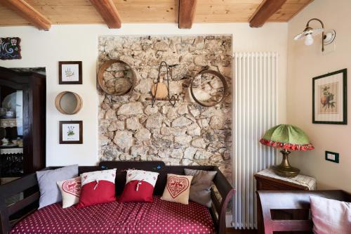 a bedroom with a stone wall and a bed with pillows at Conte Moro, ospitalità in Vanoi in Canale San Bovo