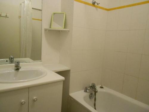 une salle de bain avec un lavabo et une baignoire et un lavabo dans l'établissement Résidence Pic De Lia - Appartement 6 personnes au centre du village MAE-6204, à Cadeilhan-Trachère