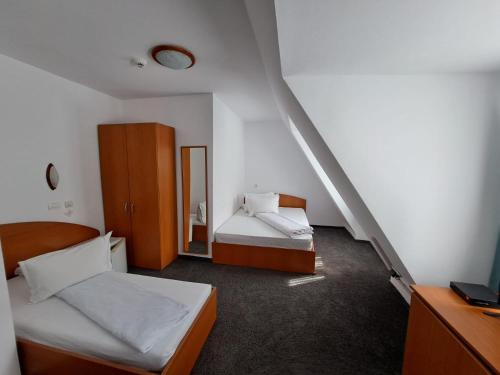 Hotel Pescarus Port Bicaz في بيكاز: غرفة نوم صغيرة بسريرين ومرآة