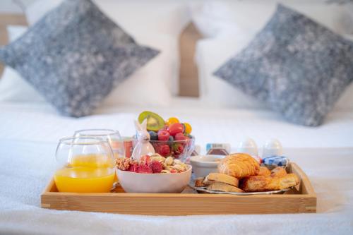 a tray of breakfast foods and fruit on a bed at GREEN PARK HOTEL PARIS in Paris