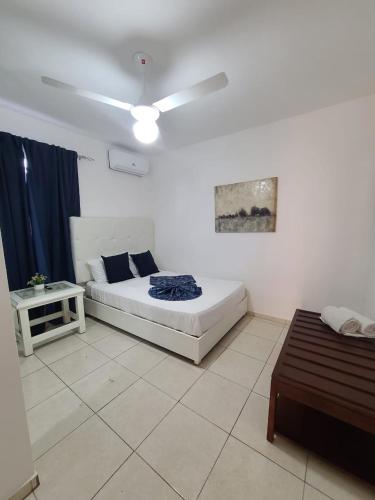een slaapkamer met een bed en een plafondventilator bij Apartamentos LC cerca de la playa in La Romana
