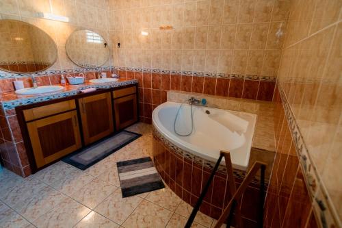 a bathroom with two sinks and a bath tub at Au coeur des Salazes in Salazie