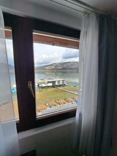 a window with a view of a body of water at Hotel Pescarus Port Bicaz in Bicaz