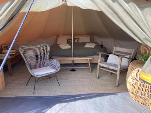 - un lit et une chaise dans une tente dans l'établissement Ô Bord de Loire, à Denée