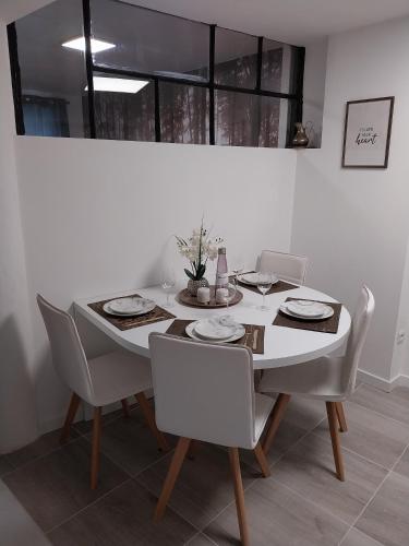 - une table à manger avec des chaises blanches, une table blanche et des chaises dans l'établissement PRIMO - Logement 4personnes, à Braux