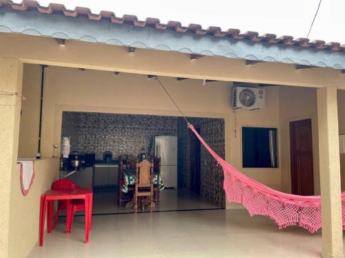 une maison avec un hamac rose dans une pièce dans l'établissement Casa para o Rondônia Rural Show, à Ji-Paraná