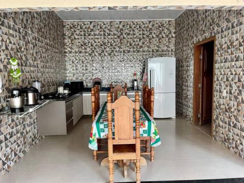 Il comprend une cuisine équipée d'une table et d'un réfrigérateur. dans l'établissement Casa para o Rondônia Rural Show, à Ji-Paraná