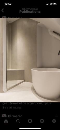 une photo d'une salle de bains avec un lavabo blanc dans l'établissement Le Nénuphar, à Neuilly-sur-Seine