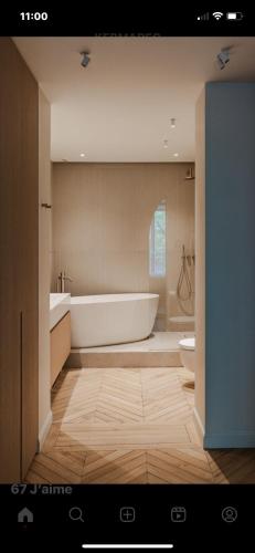 ein Bad mit einer Badewanne und einem WC in der Unterkunft Le Nénuphar in Neuilly-sur-Seine