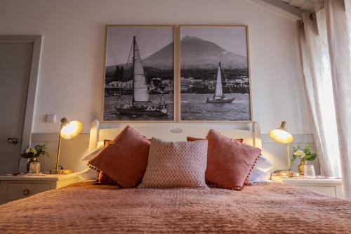 ein Schlafzimmer mit einem Bett mit zwei Bildern an der Wand in der Unterkunft Casa de Basalto in Lajes do Pico