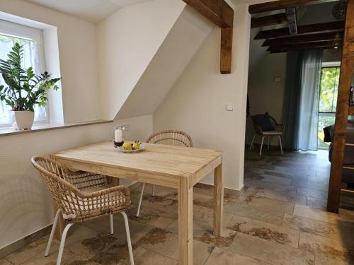 - une salle à manger avec une table et des chaises en bois dans l'établissement Ferienwohnung Carlotta, à Freyburg