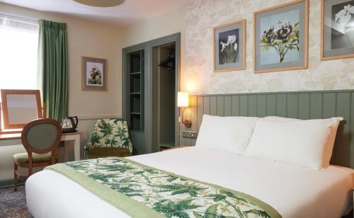 um quarto de hotel com uma cama grande e uma janela em The Kings Head Wroxham by Greene King Inns em Wroxham