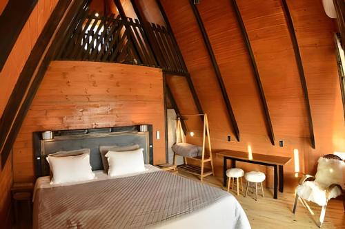 um quarto com uma cama grande e paredes de madeira em Chalé Vista do Vale em Cambará