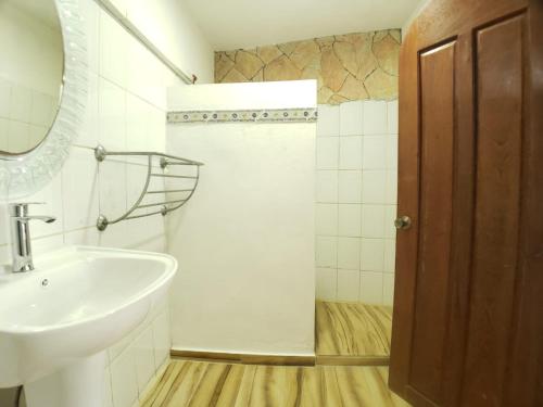 y baño con lavabo, espejo y ducha. en Immaculate 1-Bed Apartment in Cofresi, en Las Flores