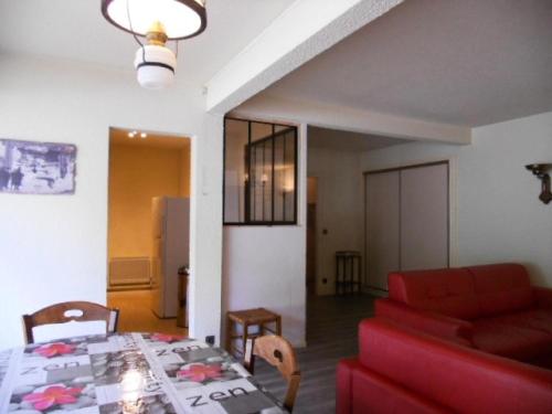 un salon avec une table et un canapé rouge dans l'établissement Résidence Le Palos - Appartement 6/8 personnes à deux pas du centre MAE-9184, à Cadeilhan-Trachère