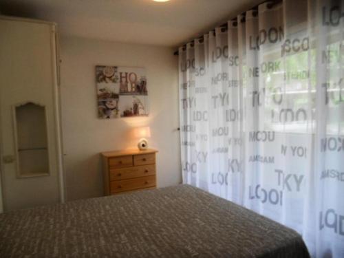 - une chambre avec un lit et une fenêtre avec un rideau dans l'établissement Résidence Le Palos - Appartement 6/8 personnes à deux pas du centre MAE-9184, à Cadeilhan-Trachère