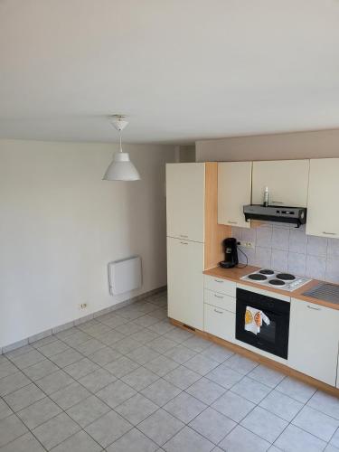 a kitchen with white cabinets and a stove at Duplex à Yerres in Yerres