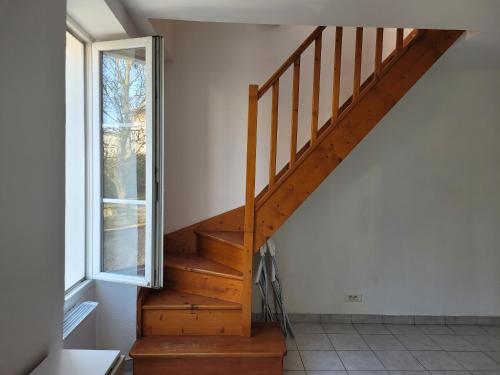- un escalier en bois dans une chambre avec fenêtre dans l'établissement Duplex à Yerres, à Yerres