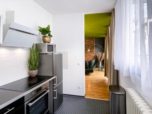 ライプツィヒにあるExklusives Leipzig City Apartment Natureのキッチン(ステンレス製の冷蔵庫付)、廊下