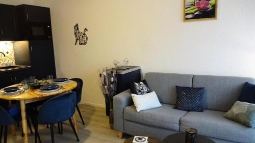 a living room with a couch and a table at Résidence Le Palos - Appartement coquet 4 personnes Résidence LE PALOS MAE-1464 in Cadeilhan-Trachère