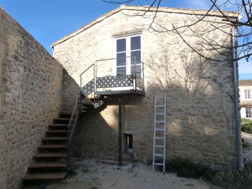 Una escalera está al lado de un edificio con ventana en Prieuré de Grignan, en Grignan
