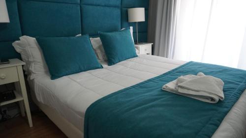 a blue bedroom with a large bed with blue pillows at Hotel Senhor de Matosinhos in Matosinhos