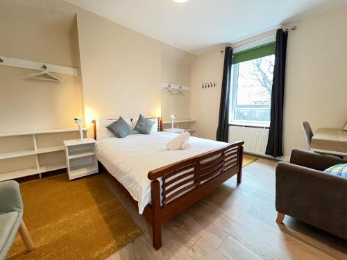 Un dormitorio con una cama grande y una ventana en West End Gem 3BR Detached Family House en Glasgow