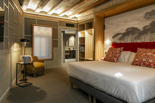 バルセロナにあるHotel La Pauのベッドルーム(大型ベッド1台、椅子付)