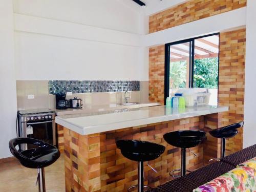 a kitchen with a counter and stools in a room at Finca la Flor del Café in Quimbaya
