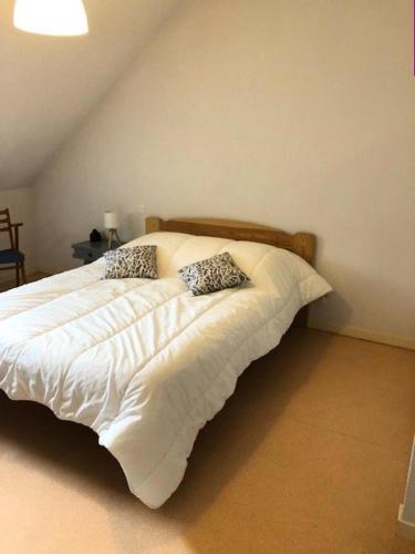 un lit avec deux oreillers dessus dans une chambre dans l'établissement Résidence Ferme De Louise - FERME DE LOUISE Appartement 6/8 personnes MAE-3864, à Guchen