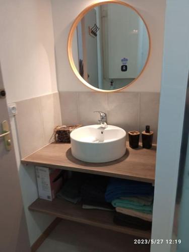 une salle de bain avec un lavabo blanc et un miroir dans l'établissement Gites Terre et Ciel, à Largentière