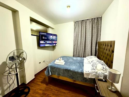 a bedroom with a bed with a fan and a tv at 200. Hermoso Departamento con Servicios Incluidos en Chorrillos in Lima