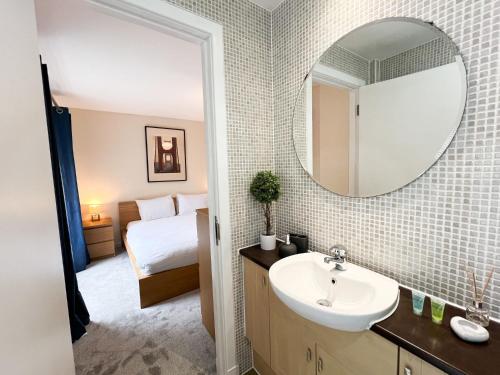 a bathroom with a sink and a mirror at Duplex Apartment in Glasgow in Glasgow