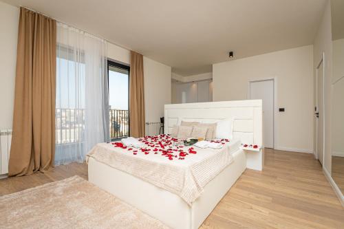 a bedroom with a bed with red roses on it at Sinfonia Lux 1205 in Sajmište