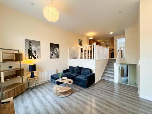 a living room with a blue couch and a staircase at Duplex Apartment in Glasgow in Glasgow