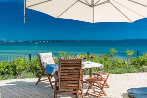 a table and two chairs and an umbrella on a patio at Villa Miri Lavender in Privlaka