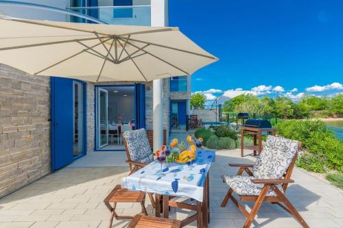 a patio with a table and an umbrella at Villa Miri Lavender in Privlaka